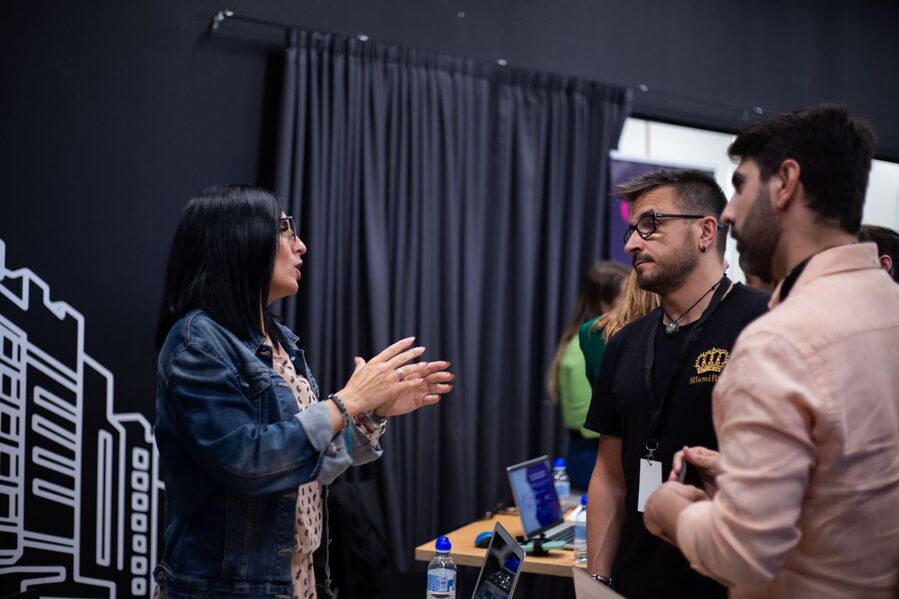 Una recruiter hablando con dos alumni